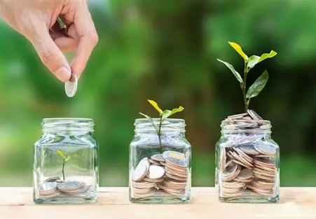 Woman managing finances on a laptop with notes and a card